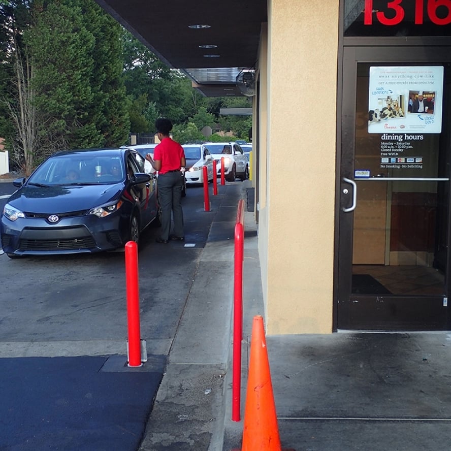 Bollards protecting a storefront entrance next to a drive lane