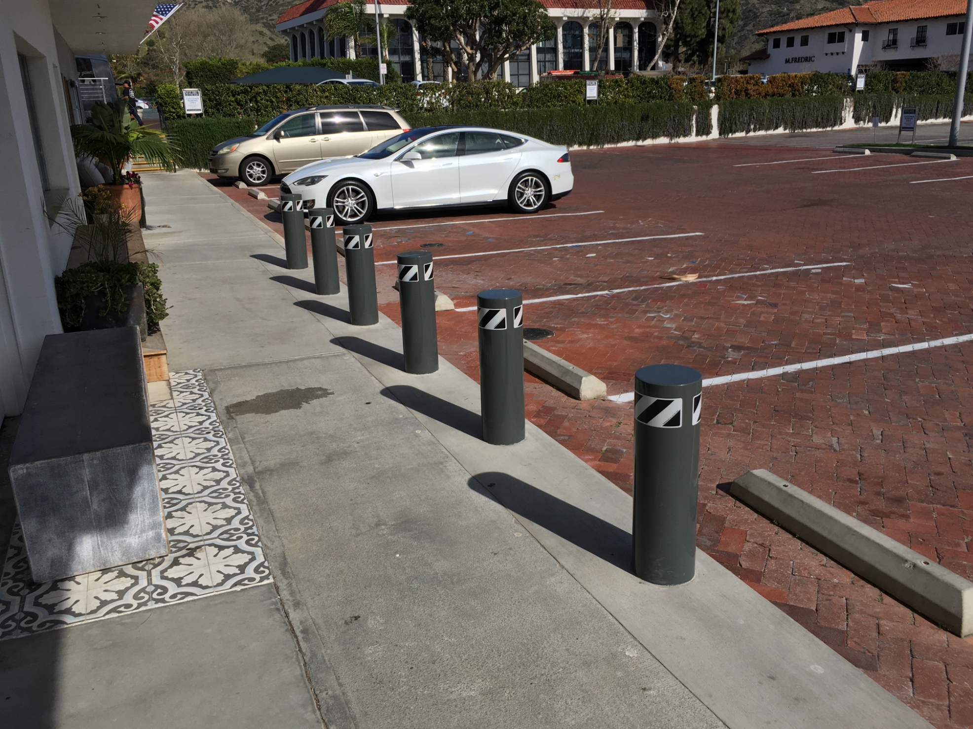 Bollards separating a parking lot from a storefront walkway at Malibu Colony Plaza