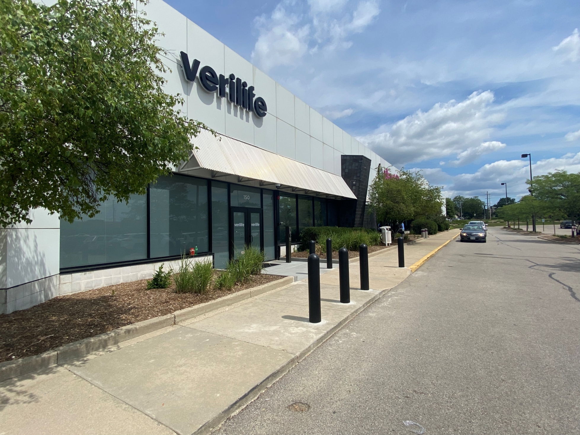Bollards lining the storefront glass line and drive lane at Verilife